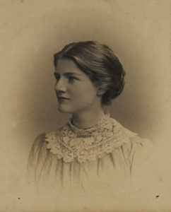 Black and white head and shoulders photograph of young woman in profile.
